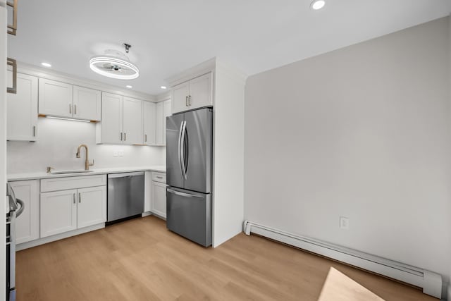 kitchen with recessed lighting, appliances with stainless steel finishes, baseboard heating, and light wood-type flooring