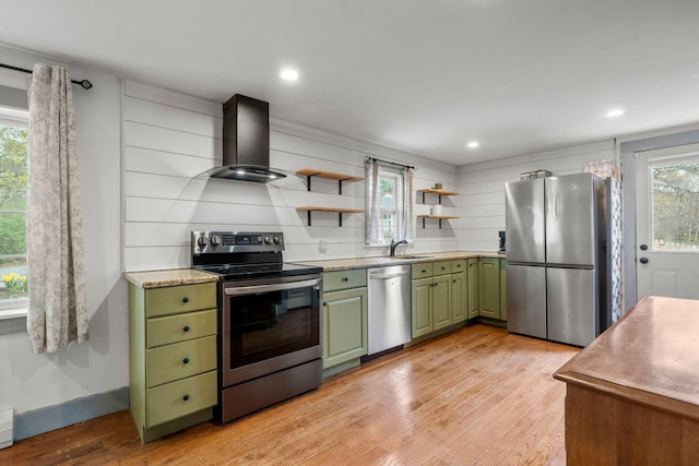 18 Race Rd, West Yarmouth, MA 02673 - kitchen featuring green cabinetry, stainless steel appliances, wall chimney range hood, a sink, and light wood-style floors