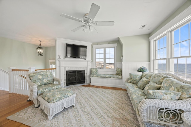 living room featuring light wood-type flooring and ceiling fan with notable chandelier