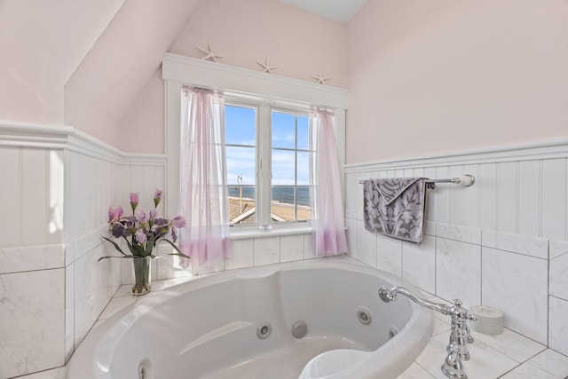 bathroom with a water view and tiled tub