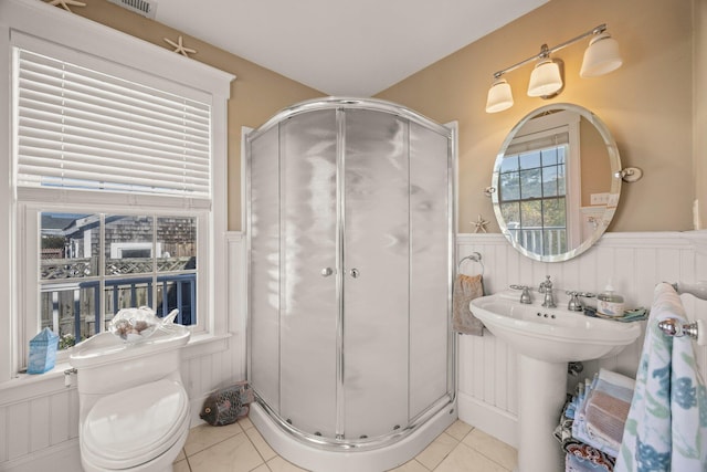 bathroom featuring toilet, tile patterned floors, and an enclosed shower