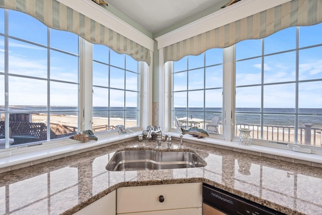 kitchen featuring dishwasher, sink, a water view, white cabinetry, and a view of the beach