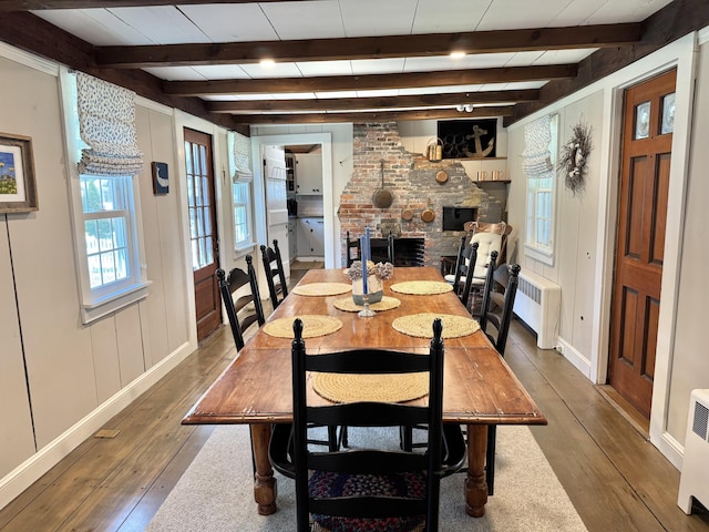 11 Willow Ln, South Yarmouth, MA 02664 - dining area with wood-type flooring, radiator heating unit, a fireplace, and beam ceiling