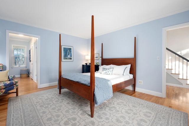 bedroom featuring crown molding and light hardwood / wood-style floors