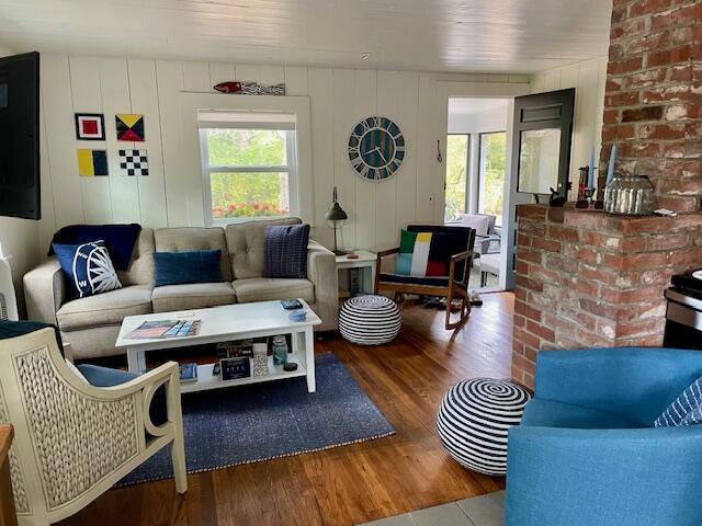 living room with baseboard heating and wood finished floors