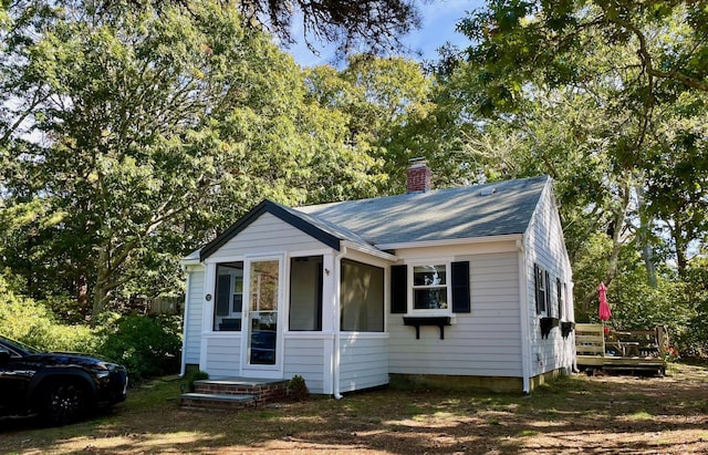 view of front of property featuring a shingled roof and a chimney