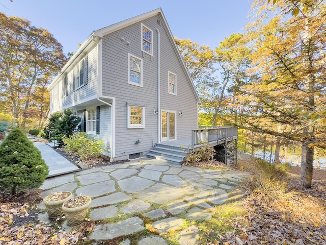 rear view of house featuring a wooden deck and a patio