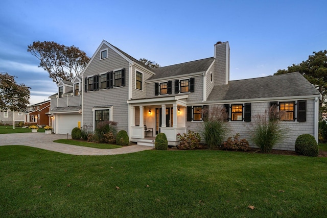 view of front of house with a garage, a front lawn, and covered porch