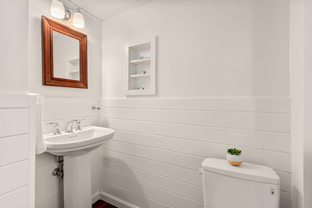 bathroom featuring built in shelves, sink, and toilet