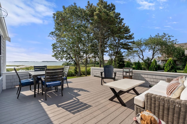 wooden terrace featuring outdoor lounge area and a water view