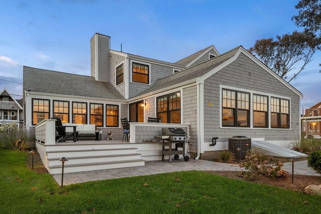 rear view of house featuring an outdoor living space, a yard, a patio area, and central AC unit