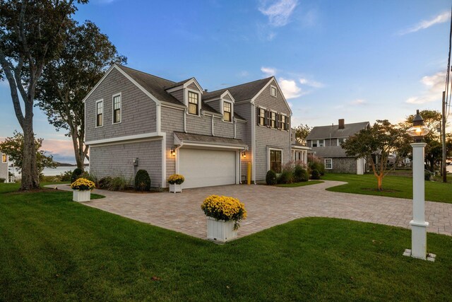 view of front of house with a garage and a lawn