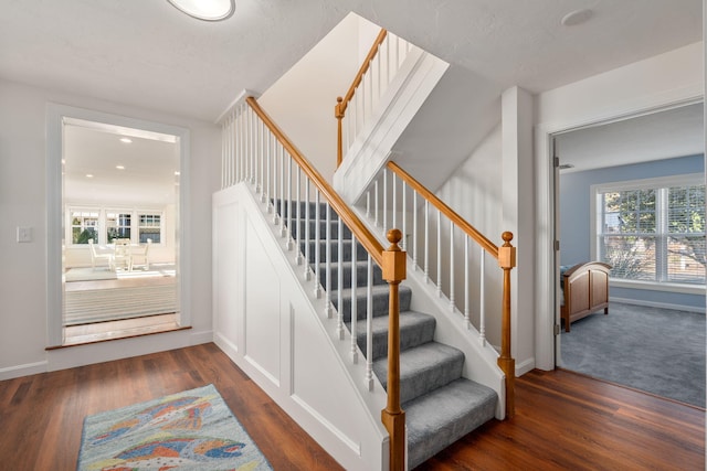 staircase with hardwood / wood-style flooring and a skylight