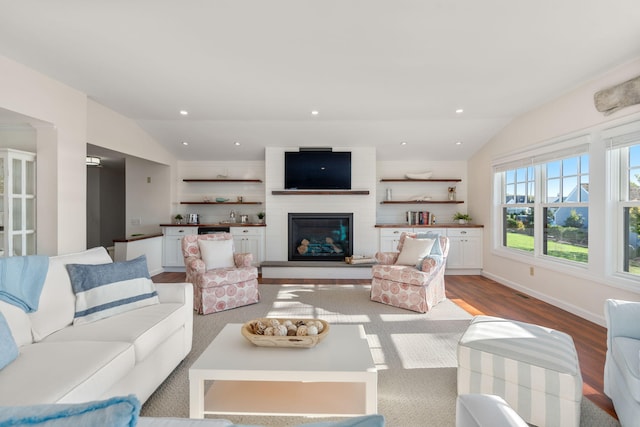 living room featuring vaulted ceiling, wood-type flooring, and a fireplace