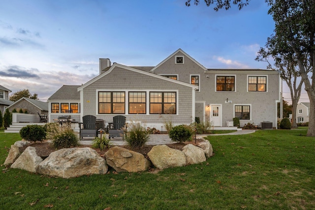 back of house with cooling unit, a patio, and a lawn