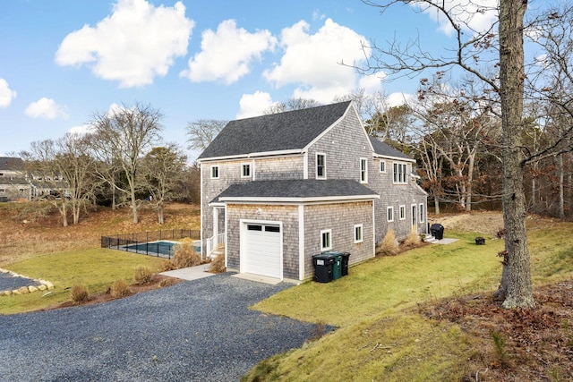 view of home's exterior with fence, driveway, a shingled roof, a garage, and a lawn