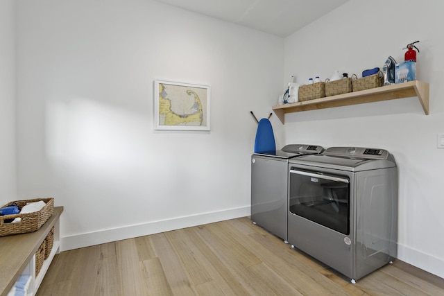 clothes washing area featuring hardwood / wood-style flooring and washing machine and clothes dryer