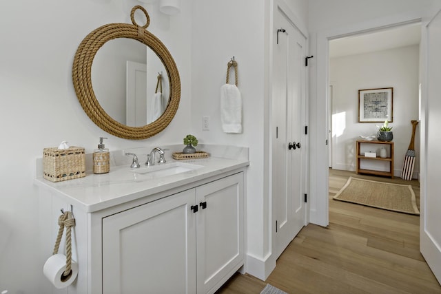 bathroom with vanity, wood finished floors, and baseboards