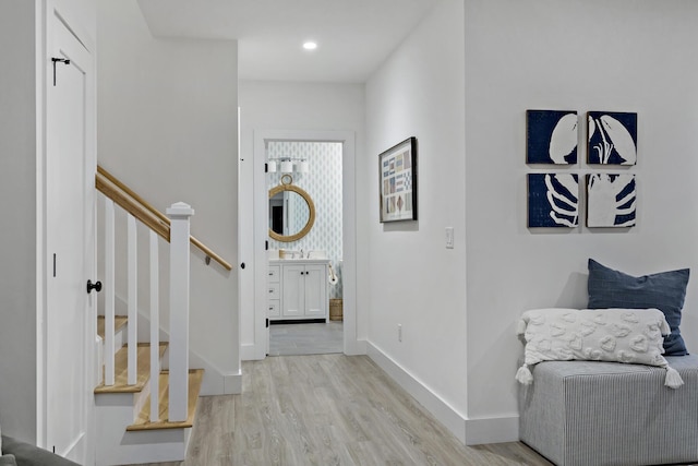 foyer entrance featuring recessed lighting, stairs, light wood-type flooring, and baseboards