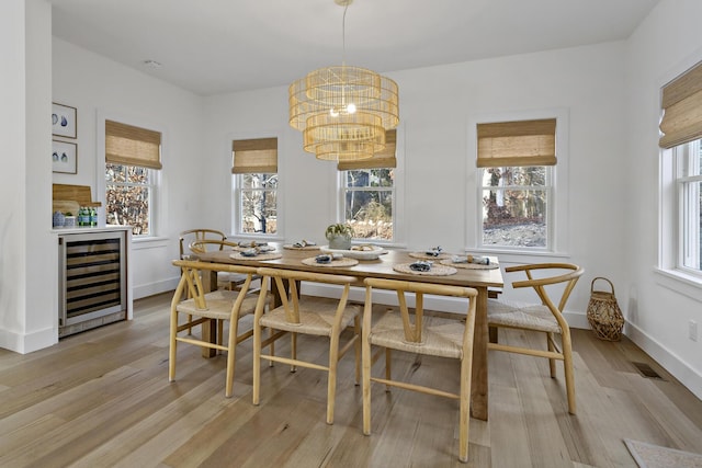 dining room with beverage cooler, plenty of natural light, and light wood finished floors