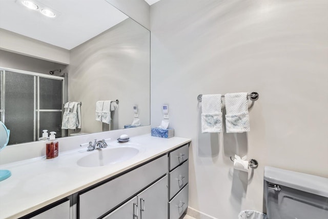 bathroom featuring toilet, an enclosed shower, and vanity