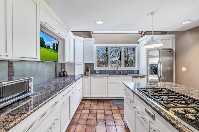 kitchen featuring white cabinets, stainless steel appliances, pendant lighting, and sink