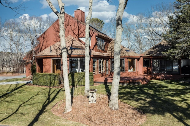 rear view of house with a deck and a lawn