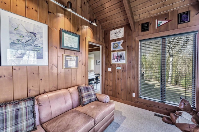 living room featuring carpet, wood walls, wooden ceiling, and lofted ceiling with beams