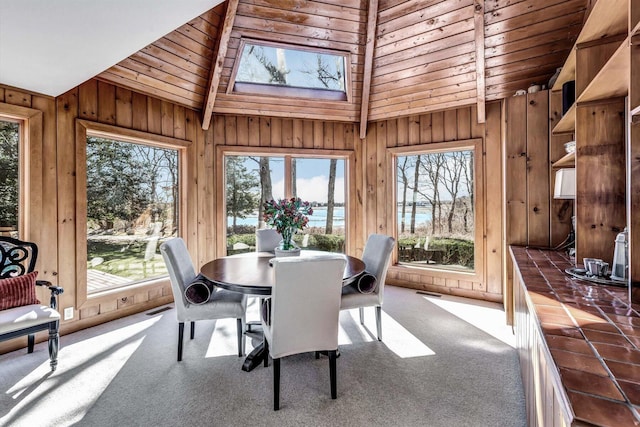 sunroom with wooden ceiling, a water view, and vaulted ceiling with beams