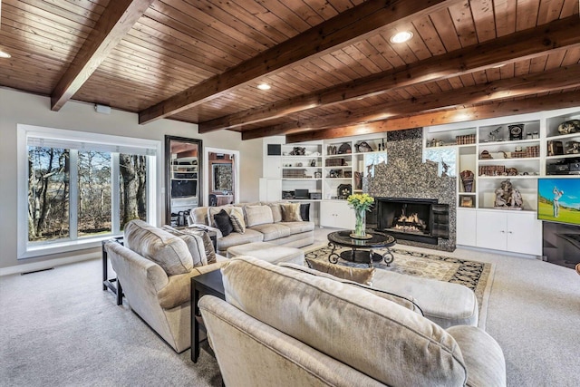 carpeted living room featuring beamed ceiling, a premium fireplace, and wood ceiling