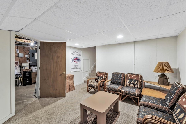 carpeted living room with electric panel and a paneled ceiling