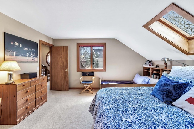 bedroom featuring lofted ceiling with skylight and light colored carpet