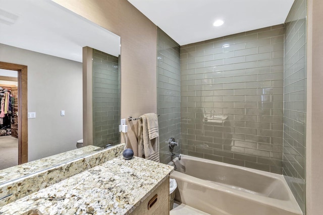 bathroom featuring tiled shower / bath combo and vanity