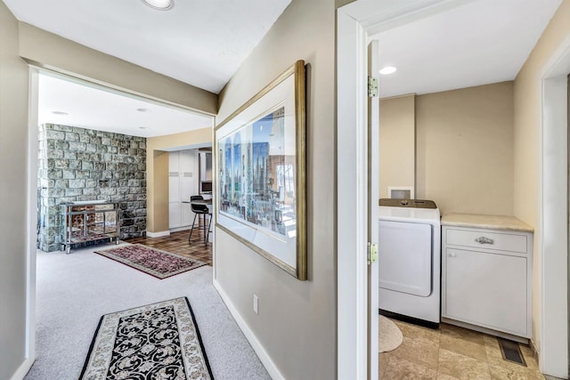 corridor with light colored carpet and washer / clothes dryer