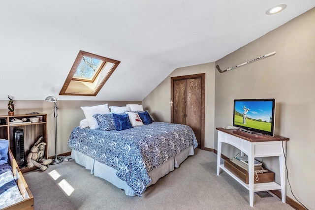 carpeted bedroom featuring lofted ceiling with skylight