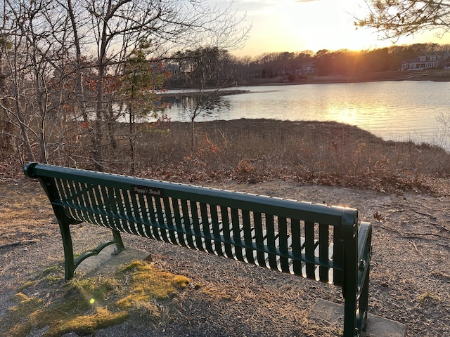 deck at dusk featuring a water view