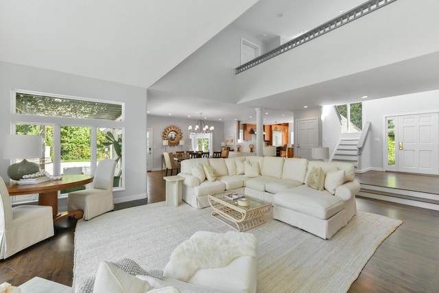 living room featuring high vaulted ceiling, a wealth of natural light, dark hardwood / wood-style flooring, and a chandelier