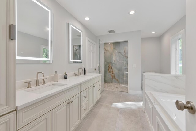 bathroom featuring tile patterned floors, vanity, and shower with separate bathtub