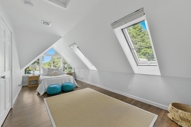 bedroom featuring vaulted ceiling with skylight and dark hardwood / wood-style floors