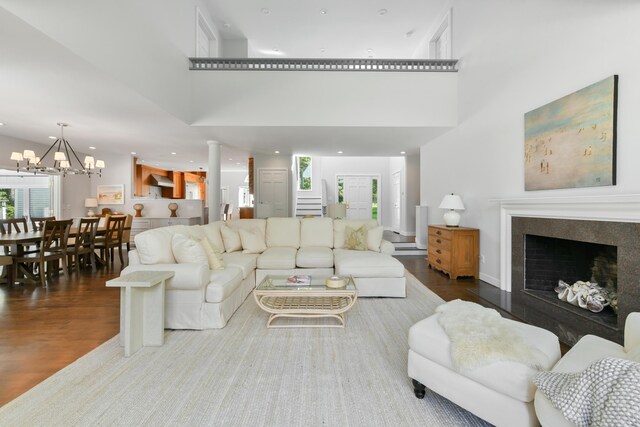 living room featuring hardwood / wood-style floors, an inviting chandelier, and a high ceiling