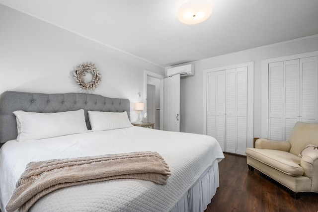 193 Main St, Sandwich, MA 02563 - bedroom with dark wood-style floors, an AC wall unit, and multiple closets
