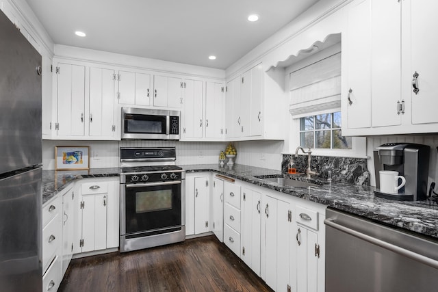 193 Main St, Sandwich, MA 02563 - kitchen with dark wood-style flooring, white cabinets, dark stone counters, stainless steel appliances, and a sink