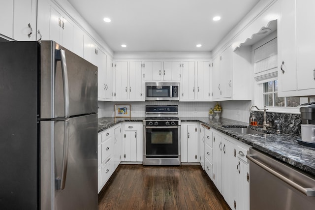 193 Main St, Sandwich, MA 02563 - kitchen featuring white cabinets, dark stone countertops, appliances with stainless steel finishes, dark wood-style flooring, and a sink
