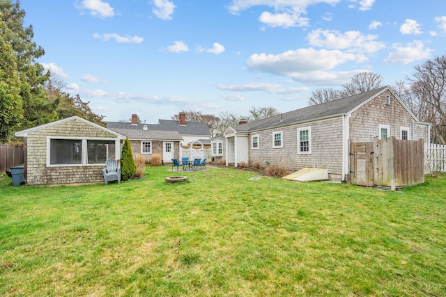 193 Main St, Sandwich, MA 02563 - rear view of house with fence, a fire pit, and a lawn
