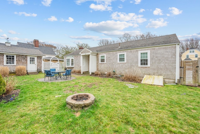 193 Main St, Sandwich, MA 02563 - back of property with an outdoor fire pit, a patio area, fence, and a lawn