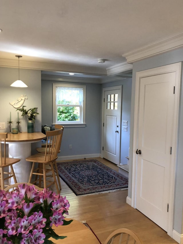 entryway featuring hardwood / wood-style flooring and ornamental molding