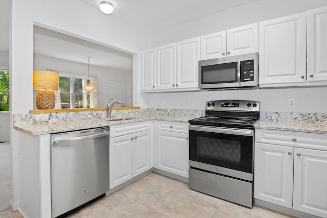 12 Wildflower Vlg, Yarmouth Port, MA 02675 - kitchen with appliances with stainless steel finishes, a sink, white cabinets, and light stone countertops