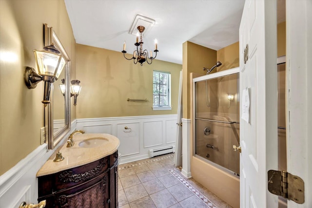 bathroom featuring wainscoting, tile patterned flooring, vanity, a baseboard radiator, and bath / shower combo with glass door