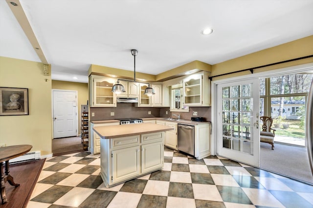 kitchen with dishwasher, light countertops, under cabinet range hood, a kitchen island, and glass insert cabinets