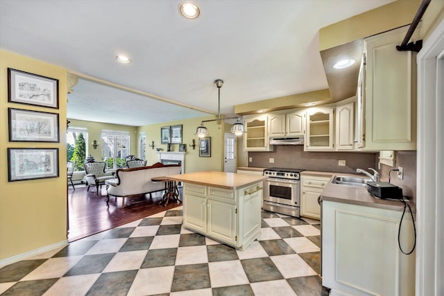 kitchen featuring a center island, tasteful backsplash, a sink, stainless steel range oven, and recessed lighting